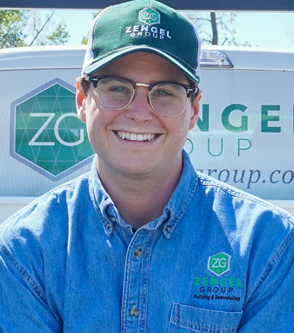 Person wearing glasses and a cap with "Zengel Group" logo, standing in front of a van with the same branding.