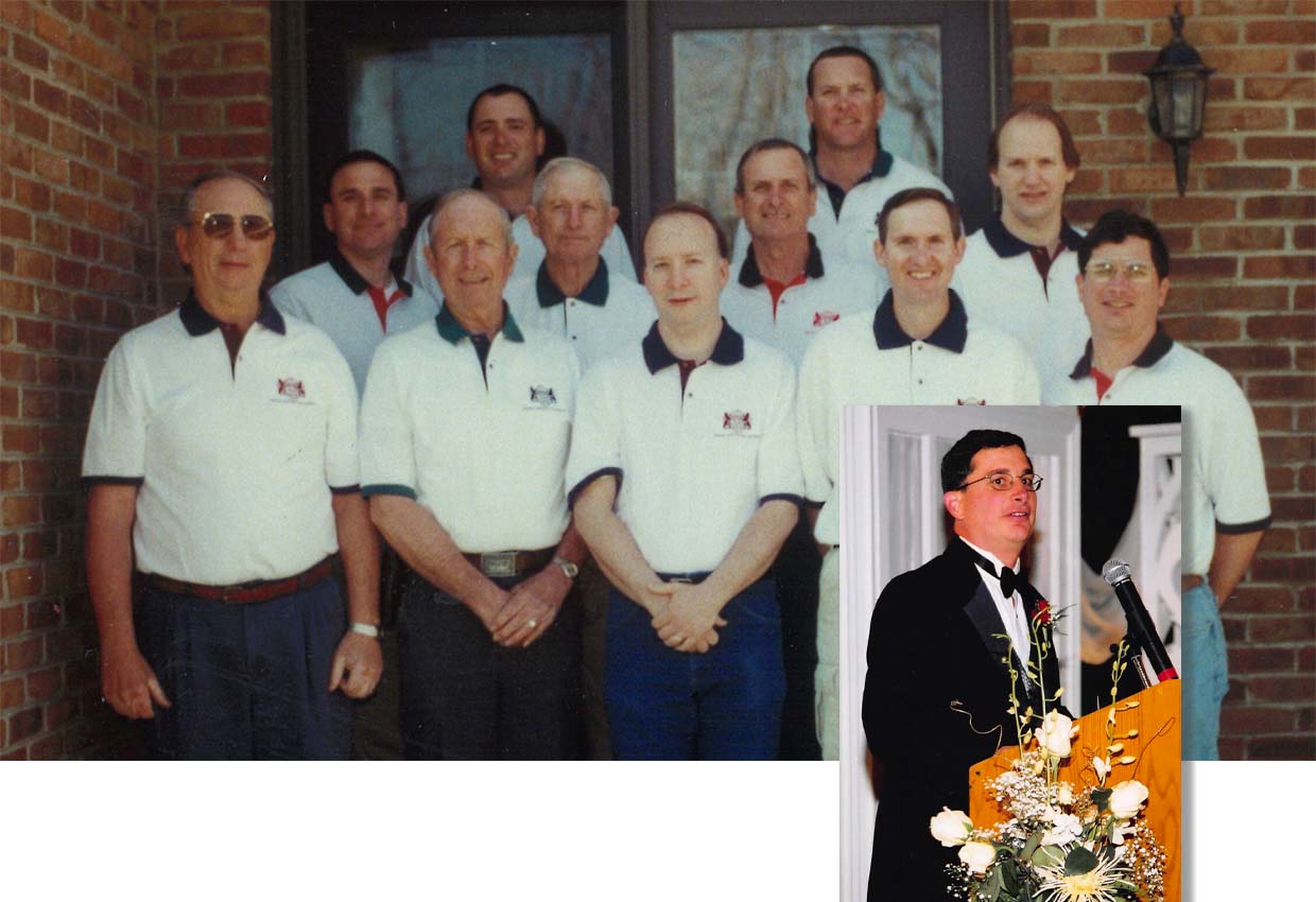 A group of ten men in white shirts pose in front of a brick building. Inset: A man in a black suit speaks at a podium with a microphone.