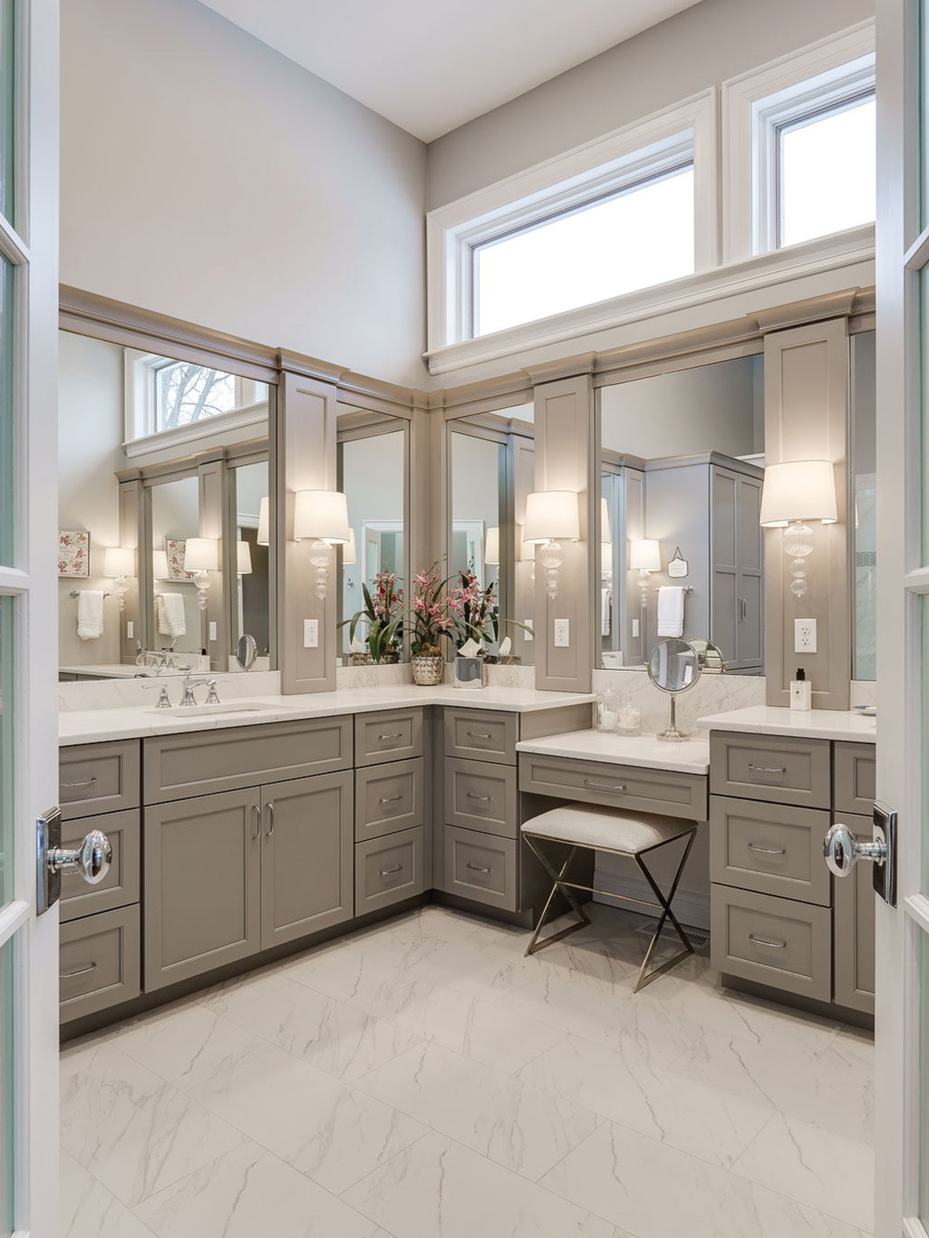 bathroom remodel service page 2 A spacious bathroom with gray cabinetry, a marble countertop, two sinks, large mirrors, wall sconces, and a small stool at a vanity area—perfect inspiration for your next bathroom remodeling Dayton project.