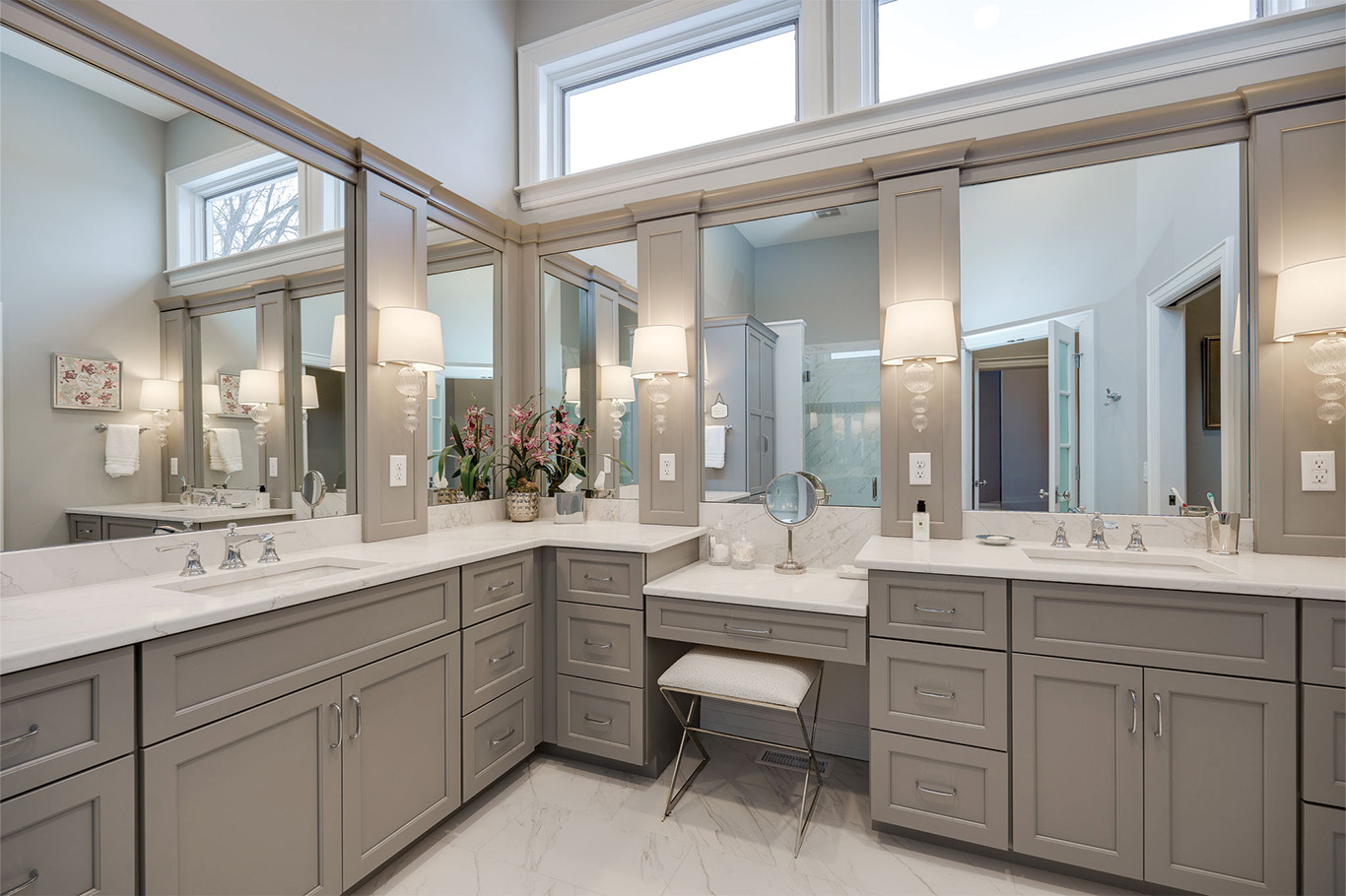 bathroom remodel service page 5 Modern bathroom with gray cabinetry, marble countertops, large mirrors, a small vanity stool, two wall sconces, and bright natural light from upper windows—perfect inspiration for your next bathroom remodeling Dayton project.